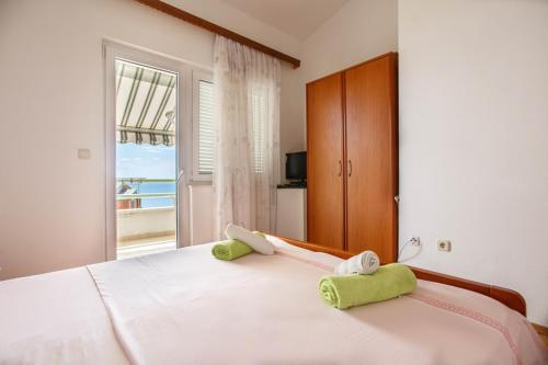 a bedroom with a large white bed with a window at Apartment Ante in Omiš