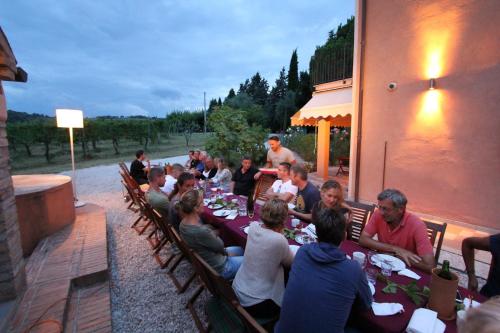 een groep mensen die aan een tafel zitten bij Country House Montesoffio in Barchi
