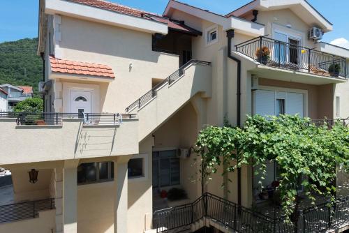 an apartment building with balconies and a tree at 42° North Apartments in Tivat