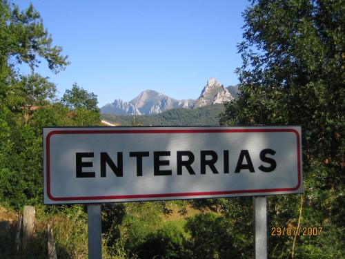 a sign that reads enterris with mountains in the background at Mirador de Enterrias in Enterria