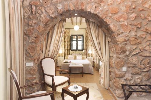 a room with a stone wall with a table and chairs at Son Mercadal in Porreres