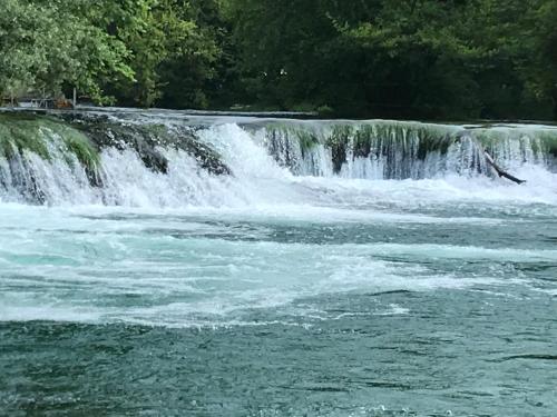 a waterfall in a river with trees in the background at Apartman EXCLUZIV in Prijedor