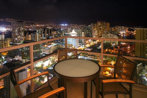 a table and chairs on a balcony with a city skyline at Ka Laʻi Waikiki Beach, LXR Hotels & Resorts in Honolulu