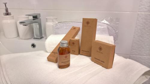 una botella de aceites esenciales y cajas en una toalla en Comfort In Warsaw Apartment, en Varsovia