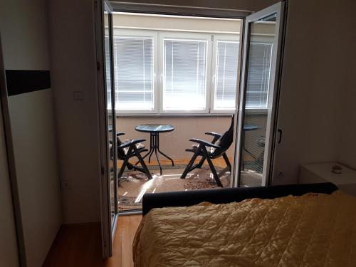 a bedroom with a mirror and a table and chairs at Lakeview rest Home in Konjic