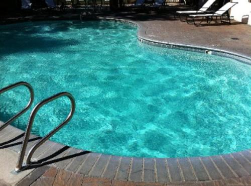 a pool of blue water with chairs in it at Mammoth Mountain Inn in Mammoth Lakes
