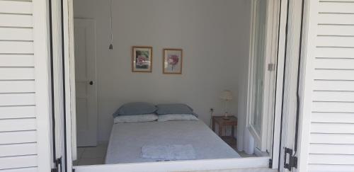 a small bedroom with a bed in a white room at Christina's panoramic view appartment in Polychrono