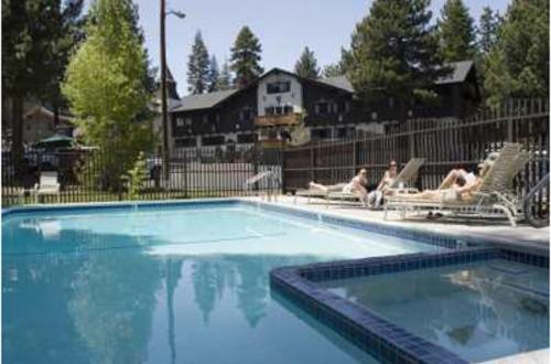 a swimming pool with two people sitting in lawn chairs at Alpenhof Lodge in Mammoth Lakes