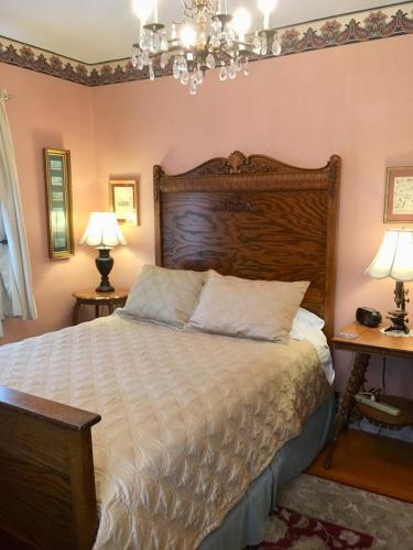 a bedroom with a large bed with a wooden headboard at Old Iron Inn Bed and Breakfast in Caribou