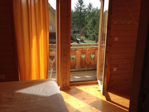 Schlafzimmer mit einer Tür, die auf eine Veranda mit Aussicht führt in der Unterkunft La Clé Des Champs in Biltzheim