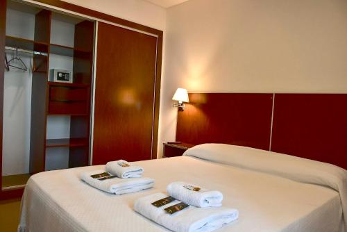 a hotel room with two towels on a bed at Hotel Playa in Comodoro Rivadavia