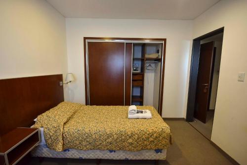 a hotel room with a bed and a closet at Hotel Playa in Comodoro Rivadavia
