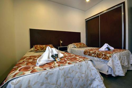 a hotel room with two beds with towels on them at Hotel Playa in Comodoro Rivadavia