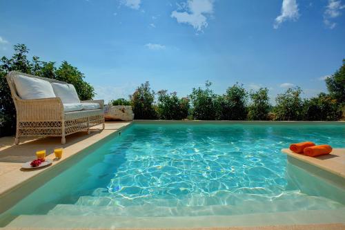 a swimming pool with a chair next to a swimming pool at Ideales Resort in Trapezaki