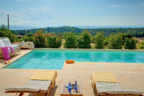 a swimming pool with two chaise lounges and a swimming pool at Ideales Resort in Trapezaki