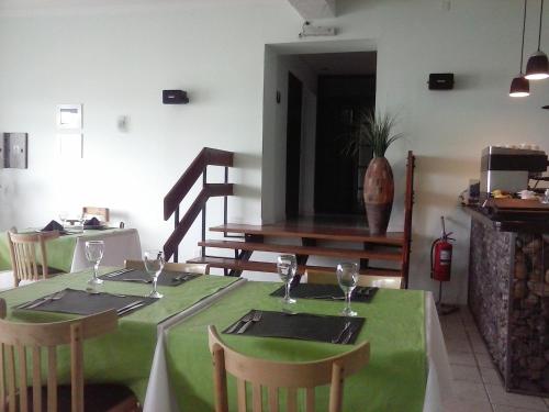 a table with a green tablecloth and two chairs with wine glasses at Hotel Playa in Comodoro Rivadavia