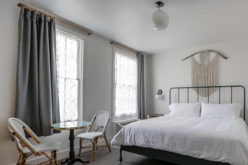 a bedroom with a bed and two chairs and a table at Surf Hotel & Chateau in Buena Vista