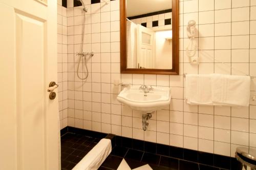 a white bathroom with a sink and a mirror at Pivovar Hotel Na Rychtě in Ústí nad Labem