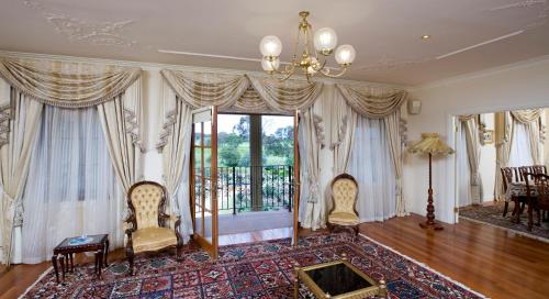 a living room with two chairs and a large window at The Residence at Barossa Chateau in Lyndoch