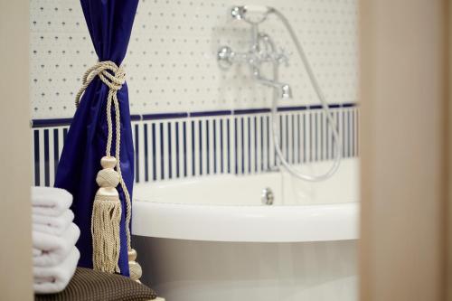 bagno con vasca, lavandino e doccia di Vintage Boutique Hotel a Lviv