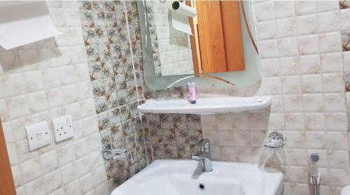 a bathroom with a sink and a mirror at روح الأصيلة للشقق المخدومة Roh Alaseilah Serviced Apartments in Taif