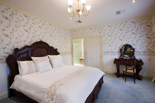 1 dormitorio con 1 cama grande y 1 mesa en The Residence at Barossa Chateau, en Lyndoch