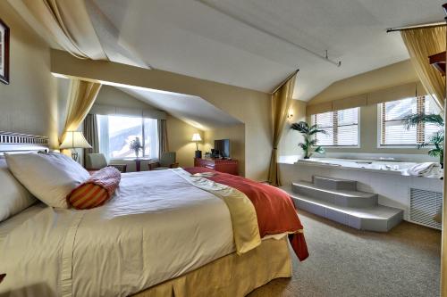 um quarto com uma cama grande e uma banheira em Sun Peaks Lodge em Sun Peaks