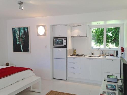 a white kitchen with white cabinets and a sink at Ohiwa Seascape Studios in Opotiki