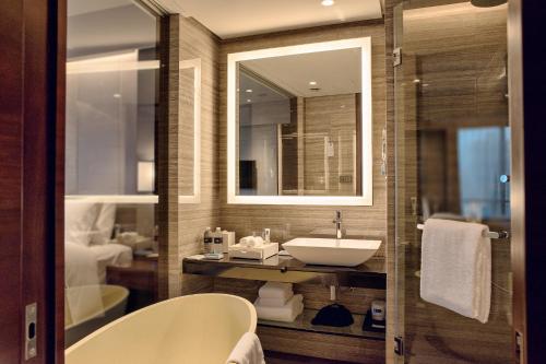 y baño con lavabo y espejo. en Amara Signature Shanghai en Shanghái