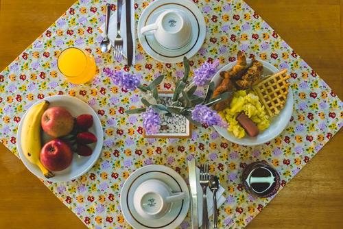 a table with breakfast foods on a polka dot table cloth at Pousada Árvore Da Coruja in Gramado