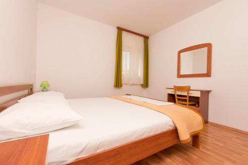 um quarto com uma cama, uma secretária e um espelho em Apartments Frane em Primošten