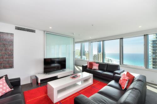 a living room with a couch and a tv at Private Apartment with Ocean Views at Q1 Resort in Gold Coast