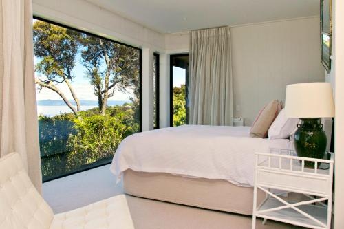 a bedroom with a bed and a large window at The Point Luxury Villa in Taupo