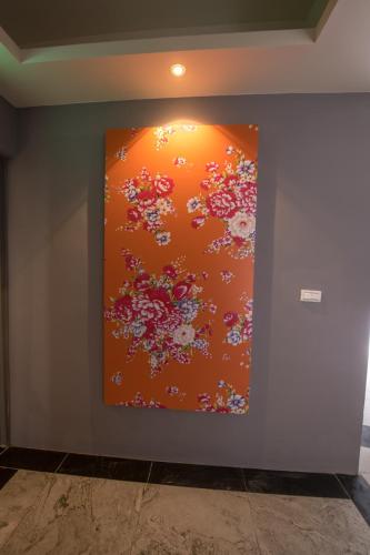 a painting on a wall with flowers on it at KET Hotel in Yuli