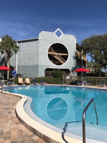 a swimming pool at a resort with a building at 180 Ocean Hibiscus Drive in Butler Beach