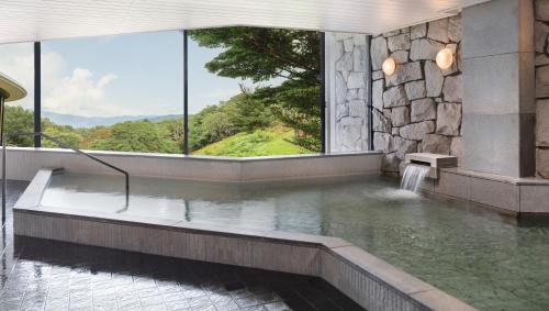 a pool of water in a building with a window at Izu Marriott Hotel Shuzenji in Izu