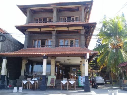 a building with tables and chairs in front of it at Padangbai Beach inn in Padangbai