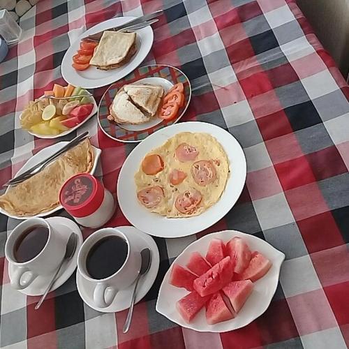 una mesa con platos de comida y tazas de café en Padangbai Beach inn, en Padangbai