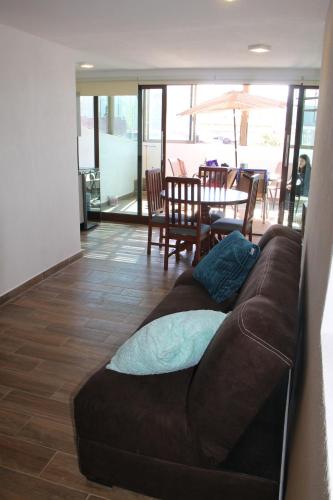 a brown couch in a living room with a table at Loft Don Silver in Zacatlán