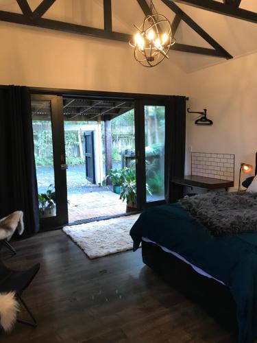 a bedroom with a bed and a sliding glass door at Studio9 in Whangarei