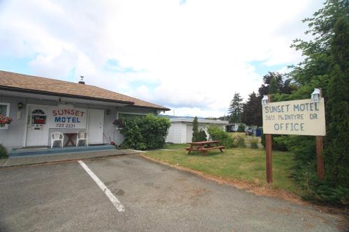 a guest motel with a sign in front of it at Sunset Motel in Port Alberni