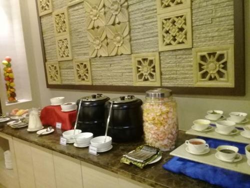 a counter top with cups and cups on it at Dreamtel Jakarta in Jakarta