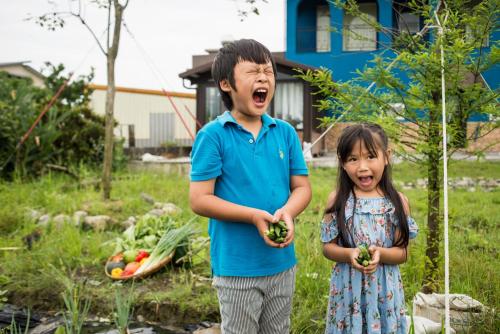 a boy and a girl holding vegetables in a yard at Fly Inn 飛旅宿 in Dongshan