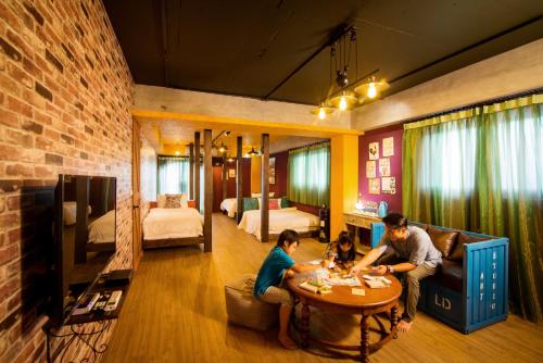a man and woman sitting at a table in a room at Fly Inn 飛旅宿 in Dongshan