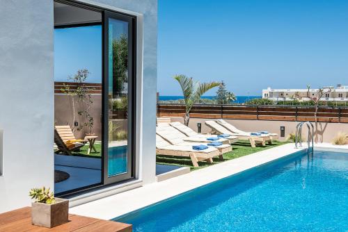 a villa with a swimming pool and a view of the ocean at Fos Villa, a Luxe House with Private Heated Pool in Galatás
