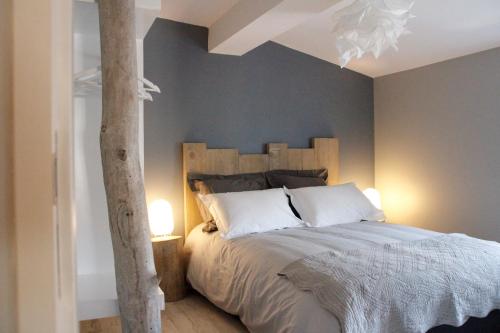 Schlafzimmer mit einem großen Bett mit einem Kopfteil aus Holz in der Unterkunft Gîte Carcasso in Carcassonne