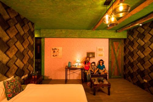 two women sitting in a room with a bed at Fly Inn 飛旅宿 in Dongshan