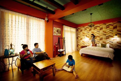 a group of people sitting in a room with a bed at Fly Inn 飛旅宿 in Dongshan