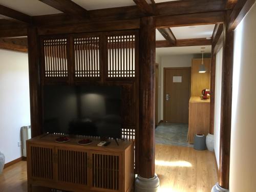 a living room with a large flat screen tv at Beijing Downtown Travelotel in Beijing