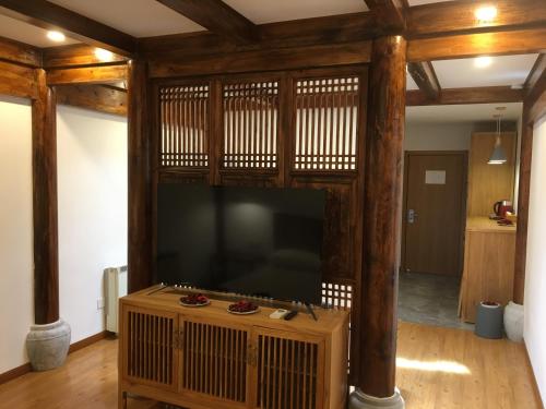 a living room with a large flat screen tv at Beijing Downtown Travelotel in Beijing
